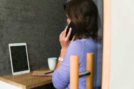 Phone booth woman violet sweater phone call tablet Studio Boost